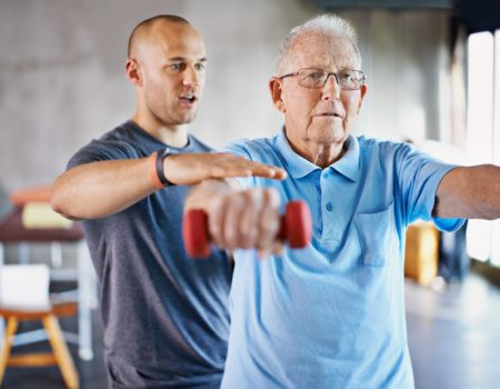 Shot of a physiotherapist helping a senior man with weights