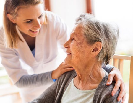 Health visitor and a senior woman during home visit. A nurse talking to an elderly woman.