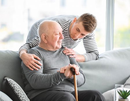 Male caregiver with senior man in nursing home