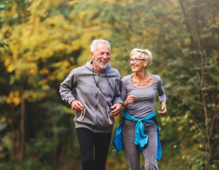 Smiling senior couple jogging in the park
