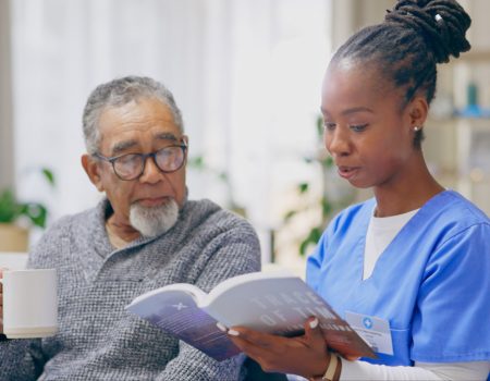 Coffee, reading book or senior man with nurse on sofa for nursing home, retirement or house. Healthcare, help or elderly patient with caregiver, black woman or volunteer in hospice for rehabilitation.